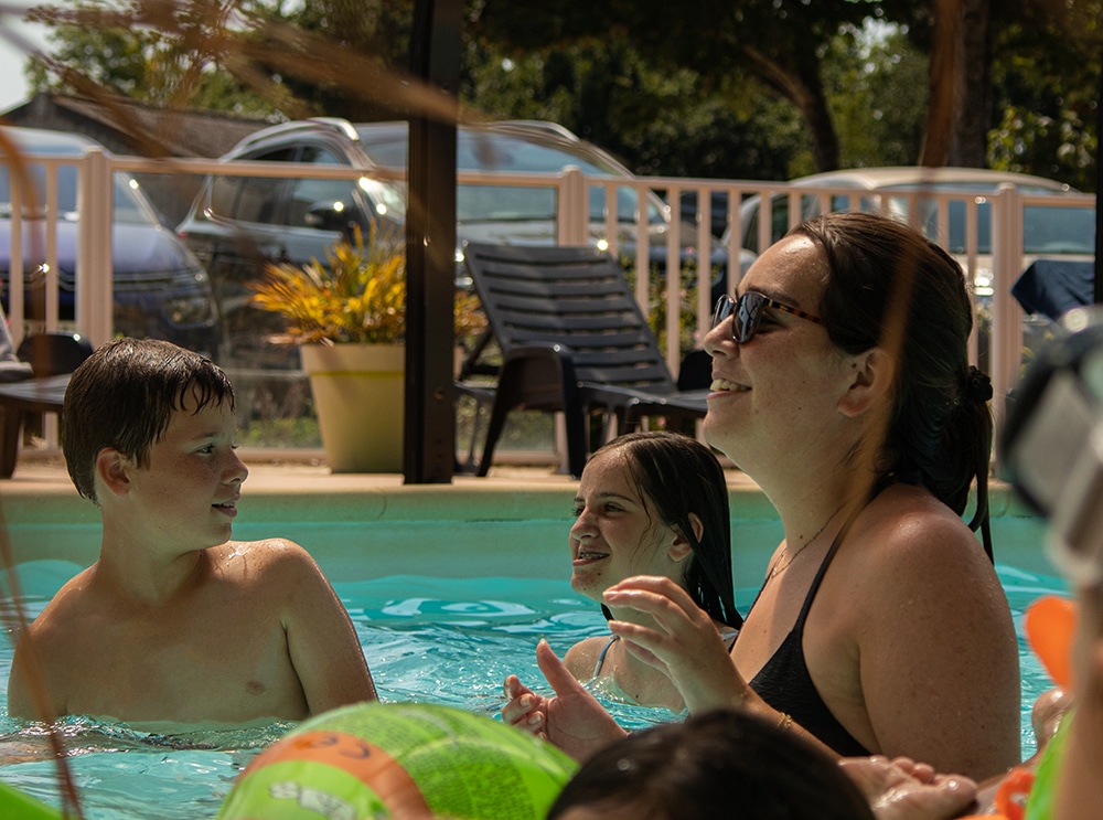 Famille se repose dans le bassin de l'espace aquatique de notre camping 3 étoiles